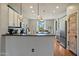 Bright kitchen with white cabinetry, stainless appliances, hardwood floors, a decorative backsplash and views into the dining room at 18585 E Ryan Rd, Queen Creek, AZ 85142