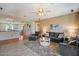 Spacious living room with plush seating, neutral paint, wood-look tile floors, and a view into the kitchen at 18585 E Ryan Rd, Queen Creek, AZ 85142