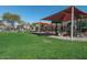 Gathering-friendly community playground featuring slides, climbing structures, and a shaded seating area on green lawn at 18585 E Ryan Rd, Queen Creek, AZ 85142