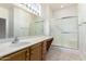 Bathroom featuring a large mirror, bright vanity lighting, and glass-enclosed shower at 19740 N Wind Rose Way, Surprise, AZ 85374