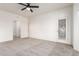 Bright bedroom with neutral carpet, ceiling fan, and entry to closet and second room at 19740 N Wind Rose Way, Surprise, AZ 85374