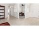Neutral-toned entryway featuring ceramic tile floors, an office with a ceiling fan, and a white front door at 19740 N Wind Rose Way, Surprise, AZ 85374