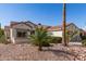 Desert-landscaped single-story home with cacti, palm trees, and a tile roof, and a two-car garage at 19740 N Wind Rose Way, Surprise, AZ 85374