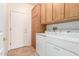 Laundry room with wooden cabinets, white washer and dryer, and access to the exterior door at 19740 N Wind Rose Way, Surprise, AZ 85374