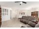 Bright living room featuring tile floors, a ceiling fan, and comfortable seating near the dining area at 19740 N Wind Rose Way, Surprise, AZ 85374