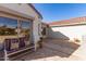 Cozy patio with neutral colored stone pavers, mature landscaping, and an outdoor seating area at 19740 N Wind Rose Way, Surprise, AZ 85374