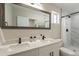 Bright bathroom features double sinks, white cabinets, a marble-tiled shower, and modern fixtures at 2068 E Orange St, Tempe, AZ 85281