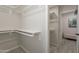 Spacious walk-in closet with built-in shelves, hanging rods, and wood-look tile flooring at 2068 E Orange St, Tempe, AZ 85281
