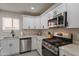 Modern kitchen featuring stainless steel appliances, white cabinetry, and quartz countertops at 2068 E Orange St, Tempe, AZ 85281