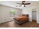 Bedroom with hardwood floors, a ceiling fan, and a gray bed frame with an orange comforter at 2316 N Mitchell St, Phoenix, AZ 85006