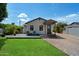 Cozy single-story home features a green lawn, a front deck and quaint curb appeal under a sunny sky at 2316 N Mitchell St, Phoenix, AZ 85006