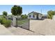 Welcoming home with a manicured lawn, brick driveway, secure gated access, and well-maintained landscaping at 2316 N Mitchell St, Phoenix, AZ 85006