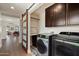 Laundry room with side-by-side washer and dryer, modern barn door, and built in storage at 2316 N Mitchell St, Phoenix, AZ 85006
