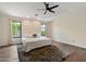Bright main bedroom with wood floors, ceiling fan, and large windows overlooking backyard at 2316 N Mitchell St, Phoenix, AZ 85006