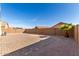 Open backyard featuring a paved patio area, desert landscaping, and secure privacy wall, ideal for outdoor enjoyment at 23789 W Chipman Rd, Buckeye, AZ 85326