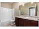Bathroom featuring a tiled shower-tub and vanity with wooden cabinetry at 23789 W Chipman Rd, Buckeye, AZ 85326
