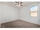 Bedroom featuring neutral carpet, a window with a view, and ceiling fan with lighting at 23789 W Chipman Rd, Buckeye, AZ 85326