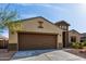 Front exterior of a single-story home with two-car garage, desert landscaping, and charming architecture at 23789 W Chipman Rd, Buckeye, AZ 85326