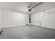 View of garage with epoxy flooring, white walls, and roll up door to provide secure parking and storage space at 23789 W Chipman Rd, Buckeye, AZ 85326