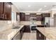Kitchen featuring dark cabinetry, stainless steel appliances, and granite countertops at 23789 W Chipman Rd, Buckeye, AZ 85326