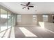 Bright living room features plush carpeting, a ceiling fan, and sliding glass doors at 23789 W Chipman Rd, Buckeye, AZ 85326