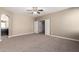 Spacious main bedroom with ceiling fan and doorway to a separate vanity area at 23789 W Chipman Rd, Buckeye, AZ 85326