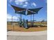 Community playground with slides and climbing equipment under a shaded canopy at 24659 W Wayland Dr, Buckeye, AZ 85326