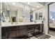 Bathroom with a dual-sink vanity, large mirror, and a peek into an adjoining bedroom at 26049 W Matthew Dr, Buckeye, AZ 85396