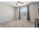 Bright bedroom boasts a large window with modern ceiling fan and neutral walls at 26049 W Matthew Dr, Buckeye, AZ 85396