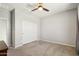 Neutral bedroom features a ceiling fan and closet with carpet flooring at 26049 W Matthew Dr, Buckeye, AZ 85396