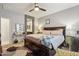 Inviting bedroom featuring a king-sized bed, a sitting area, and a glimpse into the en-suite bathroom at 26049 W Matthew Dr, Buckeye, AZ 85396