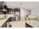 Modern kitchen featuring stainless steel appliances, dark wood cabinets, and a breakfast bar at 26049 W Matthew Dr, Buckeye, AZ 85396