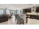 Open concept kitchen with dark cabinets, granite countertops, stainless steel appliances, and barstool seating at 26049 W Matthew Dr, Buckeye, AZ 85396