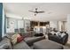 Open-concept living space featuring a sectional couch, view of the kitchen, and modern ceiling fan at 26049 W Matthew Dr, Buckeye, AZ 85396
