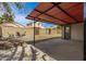 Large backyard features a covered patio, block fence, and shade trees at 2808 W Lawrence Rd, Phoenix, AZ 85017