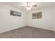 A cozy bedroom featuring neutral carpet, a ceiling fan, and natural light from two windows at 2808 W Lawrence Rd, Phoenix, AZ 85017