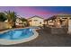 Backyard featuring a sparkling pool, hot tub, lush landscaping, and an outdoor kitchen at 2810 N 112Th Ln, Avondale, AZ 85392
