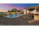 Landscaped backyard features a pool, spa, and outdoor kitchen with seating at 2810 N 112Th Ln, Avondale, AZ 85392