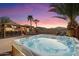 Relaxing hot tub with adjacent outdoor kitchen under the colorful sunset sky at 2810 N 112Th Ln, Avondale, AZ 85392