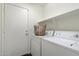 Functional laundry area with white washer, dryer, and built-in shelving at 2810 N 112Th Ln, Avondale, AZ 85392