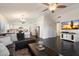 Open-concept living room with kitchen view, dark tile floors, and modern chandelier at 2810 N 112Th Ln, Avondale, AZ 85392