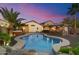Inviting backyard pool area with outdoor kitchen, hot tub and palm trees at 2810 N 112Th Ln, Avondale, AZ 85392