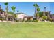 Community pool area and fenced in area with lush lawn and tropical palm trees at 2821 S Skyline -- # 135, Mesa, AZ 85212