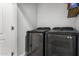Clean laundry room with modern black washing machine and dryer and a door leading to the rest of the house at 2821 S Skyline -- # 135, Mesa, AZ 85212