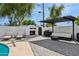 Inviting backyard with a fireplace, seating area, outdoor kitchen, and lush landscaping, ideal for entertaining at 3009 E Whitton Ave, Phoenix, AZ 85016