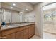 Bathroom featuring a double sink vanity with marble countertops and a tiled walk-in shower at 3033 E Claremont Ave, Phoenix, AZ 85016