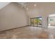 A spacious living room with travertine floors, large windows, and sliding glass doors to patio at 3033 E Claremont Ave, Phoenix, AZ 85016