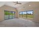 A bright main bedroom featuring sliding glass doors, and large windows with views of golf course at 3033 E Claremont Ave, Phoenix, AZ 85016
