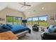 Light-filled main bedroom featuring an upholstered bed, golf course view, and a ceiling fan at 3033 E Claremont Ave, Phoenix, AZ 85016