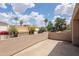 A rooftop deck featuring a stucco wall, potted plants, and a view of nearby houses and palm trees at 3033 E Claremont Ave, Phoenix, AZ 85016